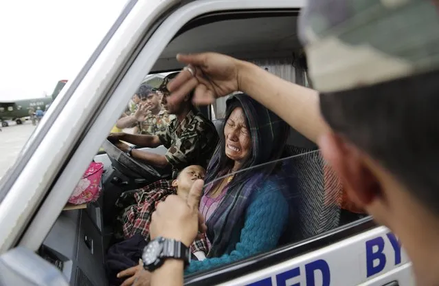 A Nepalese woman cries as she sits in an ambulance with her child wounded in Saturday's earthquake after they were evacuated from a remote area at the airport in Kathmandu, Nepal, Monday, April 27, 2015. (Photo by Altaf Qadri/AP Photo)