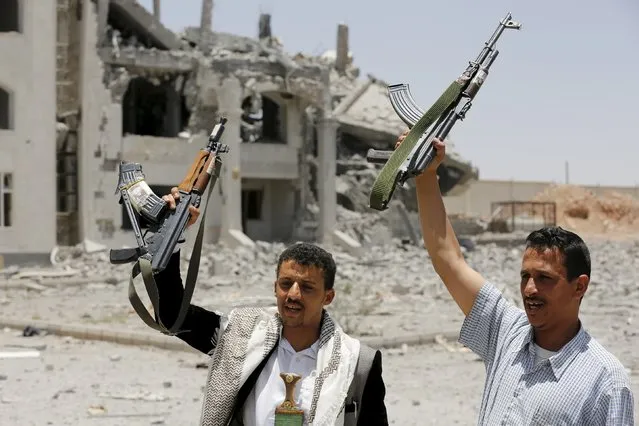 Houthi militants gesture in the yard of the residence of the military commander of the Houthi militant group, Abdullah Yahya al Hakim, after it was hit by an airstrike, in Sanaa April 28, 2015. (Photo by Khaled Abdullah/Reuters)