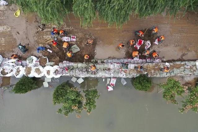 In this photo released by Xinhua News Agency, an aerial photo shows rescuers fortifying a temporary dyke against the flooding at the Lianbo Village in Hejin City, in northern China's Shanxi Province, Sunday, October 10, 2021. (Photo by Zhan Yan/Xinhua via AP Photo)