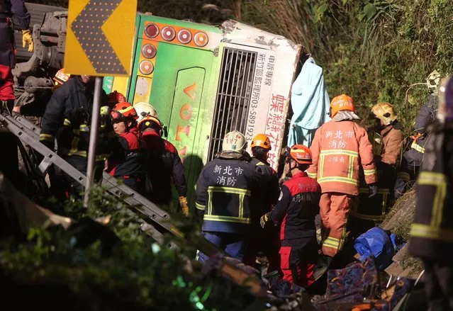 Members of rescue team at the scene where a bus collided with a car on a highway in Taipei, Taiwan, Monday, February 13, 2017. A tour bus has flipped over on a highway near Taiwan's capital, killing over 30 people and trapping many others, officials said. (Photo by AP Photo)