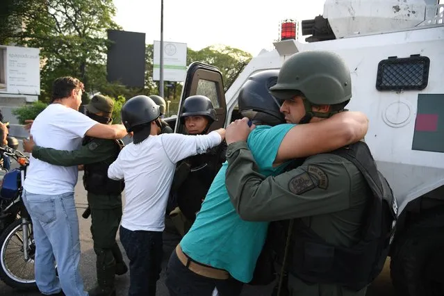 Supoprters of self-proclaimed acting president Juan Guaido hug members of the security forces in Caracas on April 30, 2019. Venezuelan opposition leader and self-proclaimed acting president  Juan Guaido said on Tuesday that troops had joined his campaign to oust President Nicolas Maduro as the government vowed to put down what it said was an attempted coup. (Photo by Yuri Cortez/AFP Photo)