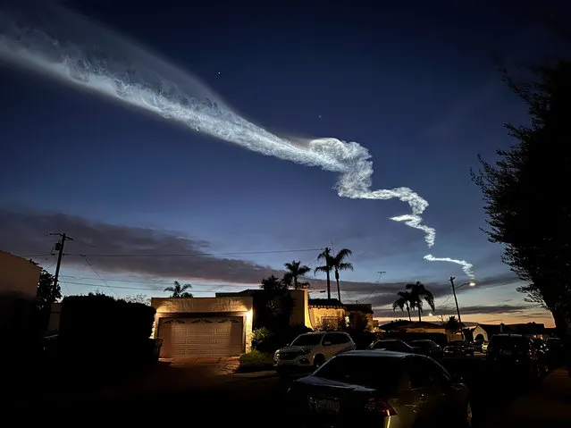 A contrail from a SpaceX Falcon 9 rocket launch is seen over homes Monday, March 18, 2024, in San Diego. The rocket, carrying Starlink satellites, launched from Vandenberg Space Force Base, Monday. (Photo by Gregory Bull/AP Photo)