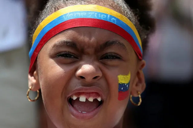 A girl with Venezuelan flag painted on her face reacts at a rally against the government of Venezuela's President Nicolas Maduro in Guatire, Venezuela on May 18, 2019. (Photo by Ivan Alvarado/Reuters)