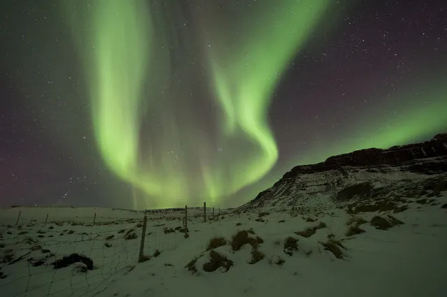 In this photo taken on Wednesday, March 1, 2017,  the Northern Lights, or aurora borealis, appear in the sky over Bifrost, Western Iceland. The Northern Lights are created as a result of collisions between gaseous particles in the Earth's atmosphere and charged particles released by the sun, according to the Northern Lights Space and Science Centre in Canada. (Photo by Rene Rossignaud/AP Photo)