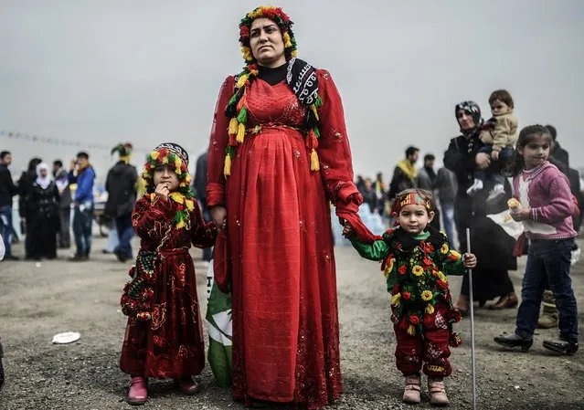 A woman stands with her daughters during Newroz celebrations on March 23, 2014 at Kazlicesme district in Istanbul. Newroz, which means “new day” in Kurdish, marks the first day of Spring. (Photo by Bulent Kilic/AFP Photo)