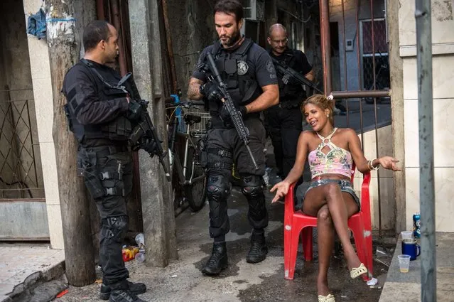 PM paramilitary police CORE elite unit personnel patrol the Favela da Mare shantytown complex in Rio de Janeiro, Brazil, on March 30, 2014 early morning. More than 1,000 police backed by the military and armored vehicles occupied the vast Mare favela near Rio's international airport at dawn Sunday, just 74 days before the World Cup. (Photo by Yasuyoshi Chiba/AFP Photo)