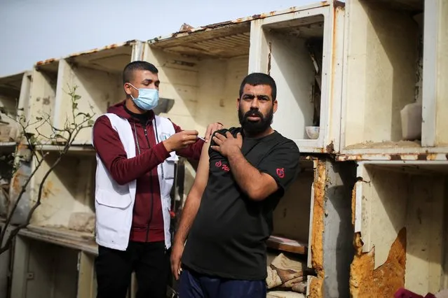 A Palestinian medical worker vaccinates a Palestinian man against the coronavirus disease (COVID-19), in Khan Younis in southern Gaza Strip on December 12, 2021. (Photo by Ibraheem Abu Mustafa/Reuters)