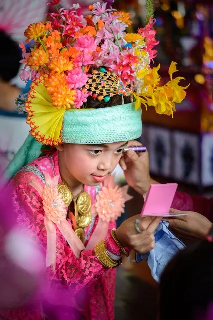 “The Crystal Son”. An initiate is checking his make up that his mother is applying to her sun during Poi Sang Long (festival of the Crystal Sons) in Mae Hong Son, Northern Thailand. This colourful festival is held every April in Northern Thailand. Photo location: Wat Don Chedi, Mae Hong Son, Thailand. (Photo and caption by Jeroen van Aar/National Geographic Photo Contest)