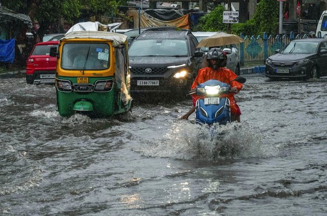 Vehicles move through a waterlogged street in Kolkata, India, as rain continues after cyclone Remal made a landfall near Bangladesh-India border, Monday, May 27, 2024. (Photo by Bikas Das/AP Photo)