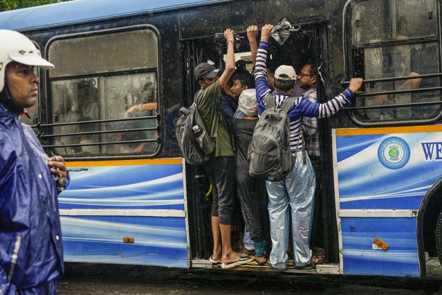 Commuters travel in a crowded bus in Kolkata, India, as rain continues after cyclone Remal made a landfall near Bangladesh-India border, Monday, May 27, 2024. (Photo by Bikas Das/AP Photo)