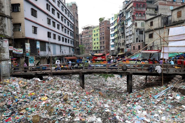 A canal in Dhaka's Keraniganj has been filled with garbage on May 15, 2024. All wastes from nearby houses, shops and garments are dumped into this canal. There is no water flow in the canal due to filling. Children play on this waste. (Photo by Syed Mahabubul Kader/ZUMA Press Wire/Rex Features/Shutterstock)