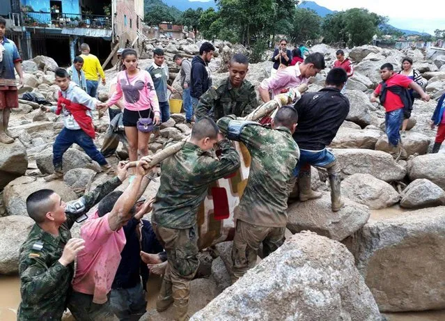 A handout photo made available by the Colombian Army shows soldiers and inhabitants evacuating a victim after a landslide in Mocoa, province of Putumayo, Colombia, on 01 April 2017. At least 15 people died and dozens were injured in a landslide that ocurred the previous night in Mocoa after several rivers overflowed due to heavy rains. (Photo by EPA/Colombian Army)