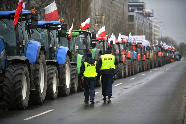 Polish farmers, members of the Polish conservative agrarianism political movement AGROunia, block a street during a protest in Warsaw, Poland, 23 February 2022. Farmers associated with the AGROunia movement called for a nationwide protest, demanding a meeting with the Polish prime minister to discuss issues such as purchase prices of agricultural products, and rising prices in stores that do not translate into farmers earnings. (Photo by Marcin Obara/EPA/EFE)