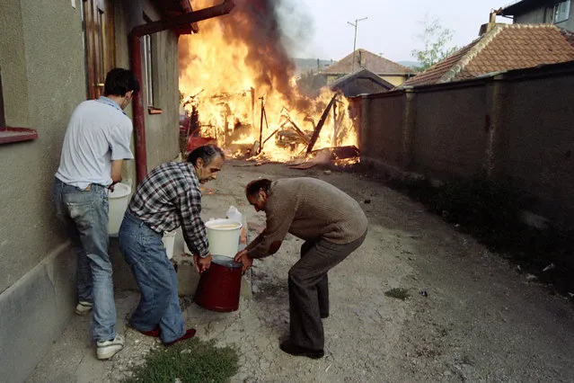 Locals are trying to put out their houses and save a Sarajevo district after a bomb attack on September 18, 1992. (Photo by Michael Evstafiev/AFP Photo)