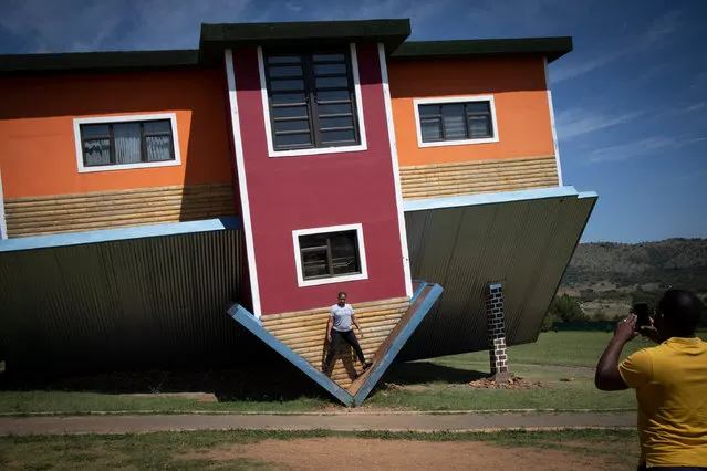 A couple takes photographs of each other at the “Upside down house” tourist attraction near Johannesburg, South Africa, 15 February 2022. The tourist attraction is a first for South Africa and appears to be a house buit upside down and features rooms within the house that are also upside down, creating a unique and mind shifting experience. (Photo by Kim Ludbrook/EPA/EFE)
