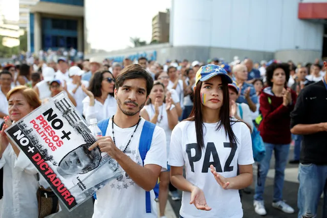 Opposition supporter holding a placard with an image of jailed opposition leader Leopoldo Lopez, that reads “No more political prisoners” and “No more dictatorship”, attend a gathering against Venezuela's President Nicolas Maduro's government in Caracas, Venezuela April 15, 2017. (Photo by Carlos Garcia Rawlins/Reuters)
