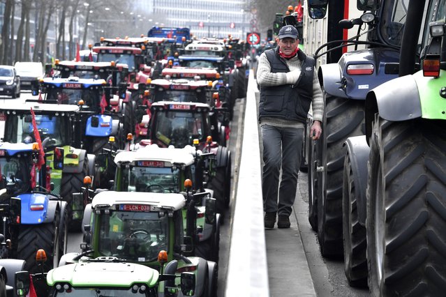 Farmers with their tractors block traffic on a road in the center of Brussels, during a demonstration, Friday, March 3, 2023. Hundreds of tractors driven by angry farmers protesting a plan to cut nitrate levels drove into Belgium's capital city on Friday causing major traffic disruption. (Photo by Geert Vanden Wijngaert/AP Photo)