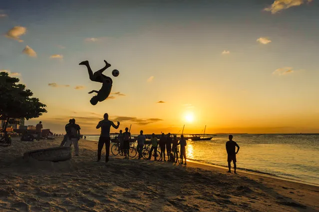 “Sunset Ball Game”. During my trip on Zanzibar, Tanzania, I found this cool sunset jump and kick game on Stonetown beach. Young locals were jumping one after the other to show their tire jumping skills while trying to kick the soccer ball at the same time. Great moment! Photo location: Stonetown, Zanzibar, Tanzania. (Photo and caption by Vincent Boisvert/National Geographic Photo Contest)