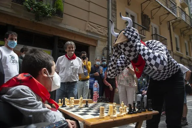 People play chess in Estafeta street in Pamplona during the “Chess Run” tournament on July 14, 2021. Some 80 players took part in the “Chess Run” in Pamplona along the same route as the traditional running of the bulls celebrated every year during the San Fermin festival that was cancelled for the second year in a row due to the Covid-19 pandemic. (Photo by Ander Gillenea/AFP Photo)