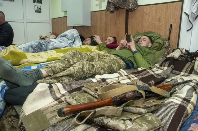 Ukrainian servicemen rest in Kharkiv, Ukraine, Tuesday, March 22, 2022. (Photo by Andrew Marienko/AP Photo)