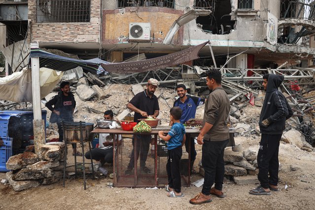 A Palestinian vendor prepares to make falafel sandwiches on a makeshift stall nextt to building rubble in Khan Yunis in the southern Gaza Strip on May 2, 2024, amid the ongoing conflict between Israel and the Hamas movement. (Photo by AFP Photo/Stringer)