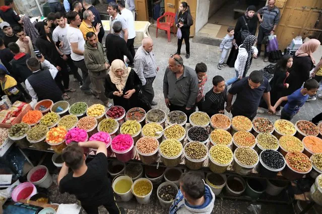 Palestinians shop during the Muslim holy month of Ramadan, at a market in the old city of Hebron, in the West Bank on April 6, 2022. The holy month of fasting observed by Muslims around the world lasts for 29 or 30 days (lunar cycle) and is dependent on the Hijri or Islamic calendar. (Photo by APAImages/Rex Features/Shutterstock)