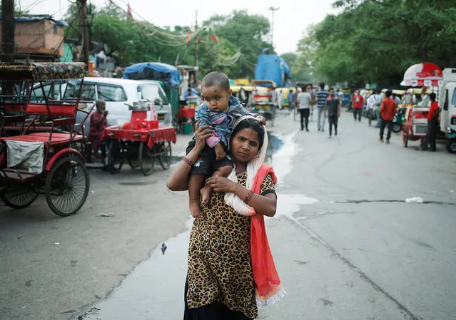 A women carries a child on her shoulder as she walks on a road in New Delhi, India May 25, 2016. (Photo by Anindito Mukherjee/Reuters)