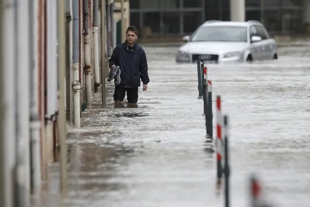 A man walks in a flooded street in Montargis in the Loiret, following heavy rain in France June 1, 2016. (Photo by Christian Hartmann/Reuters)
