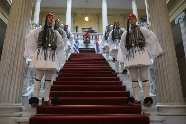 Greek Presidential guards stand inside the presidential palace during a welcome ceremony for the arrival of Serbian President Aleksandar Vucic, in Athens, on Tuesday, December 10, 2019. Vucic is in Greece on a two-day official visit. (Photo by Petros Giannakouris/AP Photo)