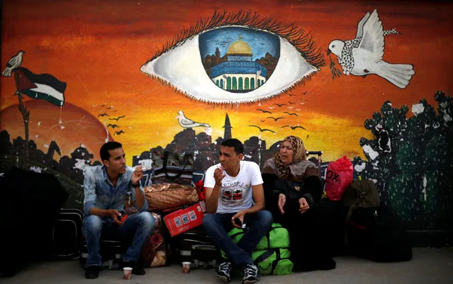 People sit in front of a mural as they wait for travel permits to cross into Egypt through the Rafah border crossing after it was opened for two days by Egyptian authorities, in the southern Gaza Strip May 11, 2016. (Photo by Suhaib Salem/Reuters)