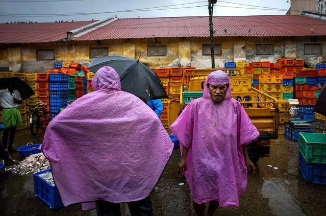 People work at a fish market in Kochi, Kerala state, India, Tuesday, May 17, 2022. India's Meteorological Department expects the southwest monsoon to arrive at country's southern coast ahead of its normal schedule this year. (Photo by R.S. Iyer/AP Photo)
