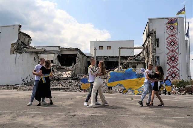 Graduates of a local lyceum dance in front of the local Palace of Culture destroyed by a Russian military strike, as they celebrate the last day of school amid Russia's attack on Ukraine, in the town of Derhachi, Kharkiv region, Ukraine on June 17, 2023. (Photo by Sofiia Gatilova/Reuters)