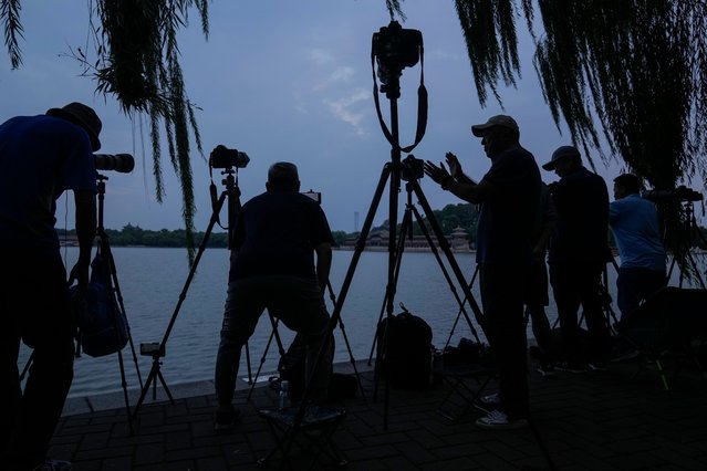 Photography enthusiasts setup their cameras as they wait to capture the full supermoon at Beihai Park in Beijing, Wednesday, September 18, 2024. (Photo by Andy Wong/AP Photo)