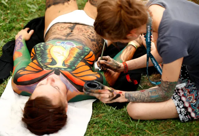An artist touches up makeup on a model during the “World Bodypainting Festival 2017” in Klagenfurt, Austria on July 28, 2017. (Photo by Leonhard Foeger/Reuters)