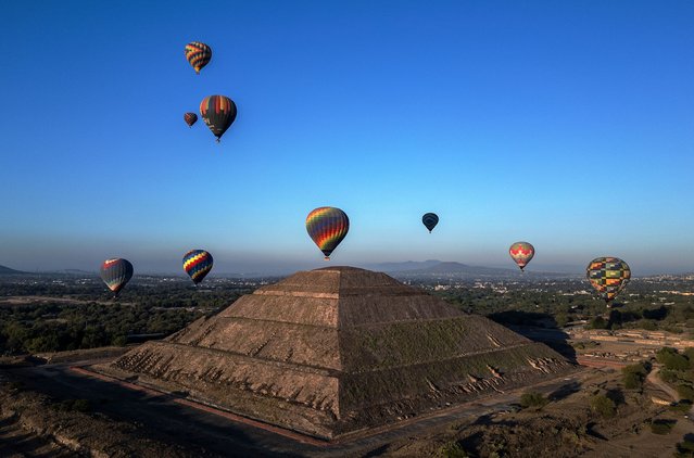 Hot air balloons fly over the Teotihuacan pyramids in the San Juan Teotihuacan municipality, Mexico State, during the spring equinox celebration on March 21, 2024. (Photo by Carl de Souza/AFP Photo)