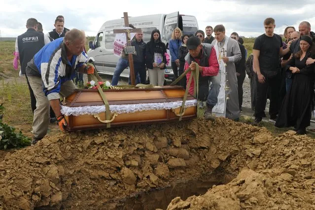 Men lower the coffin of Liza, 4-year-old girl killed by Russian attack, during a funeral ceremony in Vinnytsia, Ukraine, Sunday, July 17, 2022. (Photo by Efrem Lukatsky/AP Photo)