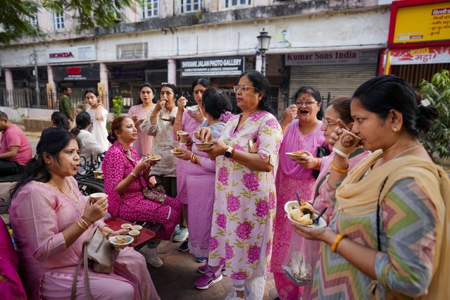 Morning walkers chat over snacks and tea outside a tea stall in the Hazratganj shopping area in Lucknow, India, Thursday, November 7, 2024. (Photo by Rajesh Kumar Singh/AP Photo)