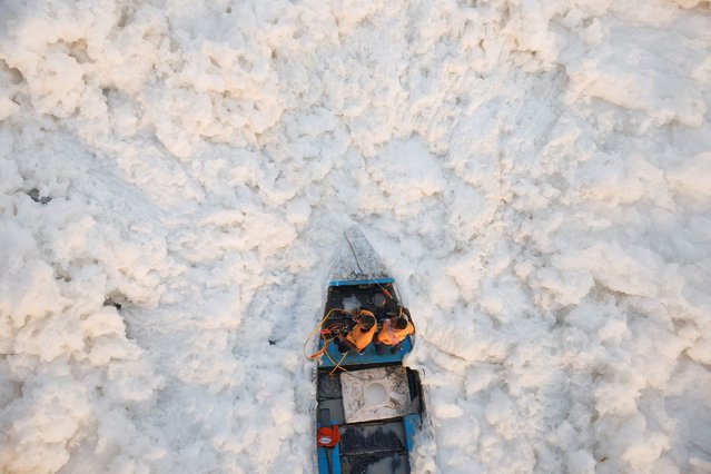 Workers with the Delhi Government spray chemicals to clean the toxic foam in the polluted Yamuna river on a smoggy morning in New Delhi, India on November 5, 2024. (Photo by Anushree Fadnavis/Reuters)