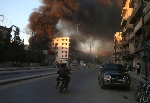 Smoke billows in the rebel-held Salihin neighbourhood of the Syrian northern city of Aleppo following a reported air strike on July 9, 2016. The Syrian Observatory for Human Rights said fresh government air strikes on rebel-held Aleppo killed four civilians on July 9, adding that opposition fighters had renewed rocket fire on government-held districts. The local civil defence unit said one of its centres had been targeted and two volunteers killed in the government air strikes. (Photo by Fadi Al-Halabi/AFP Photo)