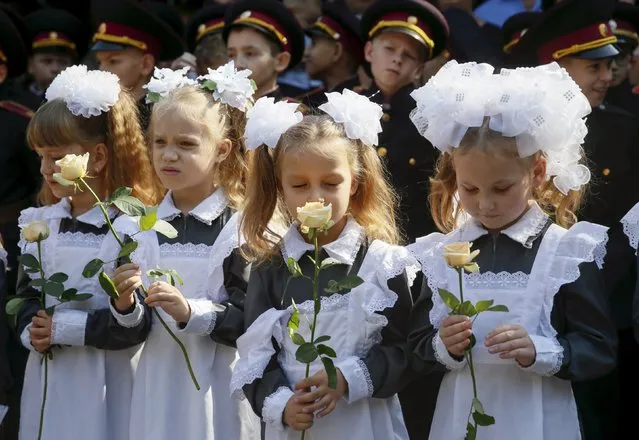 First graders of a cadet's lyceum hold flowers as they attend a ceremony to mark the start of the new school year in Kiev, Ukraine, September 1, 2015. (Photo by Valentyn Ogirenko/Reuters)