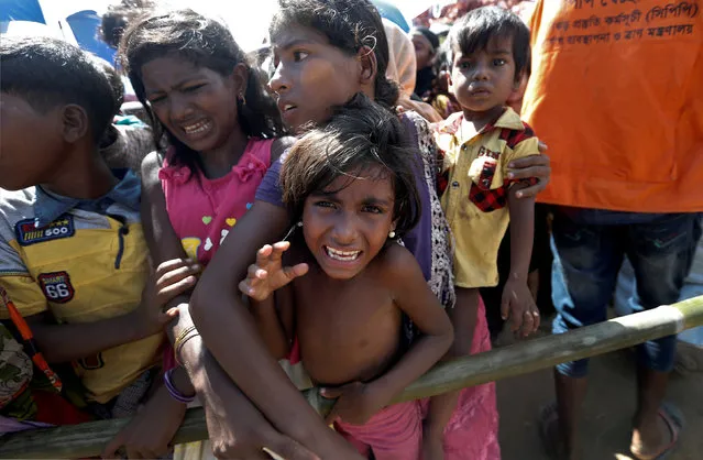 A Rohingya refugee girl reacts as people wait to receive aid in Cox's Bazar, Bangladesh, September 25, 2017. (Photo by Cathal McNaughton/Reuters)