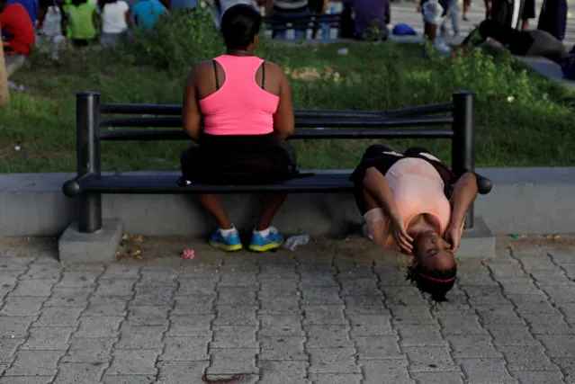A woman does crunches on a bench at a public park in Port-au-Prince, Haiti July 28, 2016. (Photo by Andres Martinez Casares/Reuters)