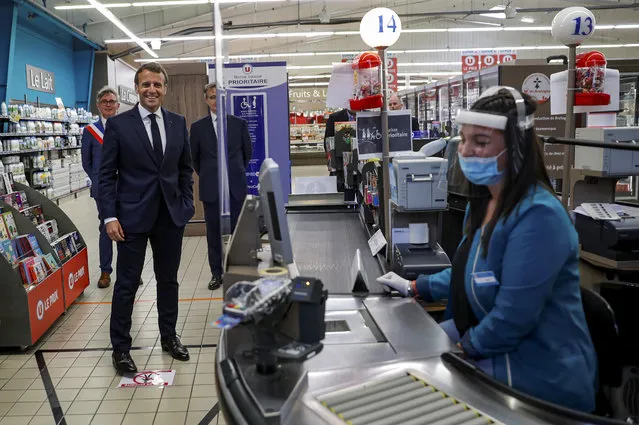 A cashier jokes with French President Emmanuel Macron as he visits a Super U supermarket about the partnership with local producers in Saint-Pol-de-Leon during a day trip centered on agriculture amid the coronavirus disease (COVID-19) outbreak in Brittany, France, April 22, 2020. (Photo by Stephane Mahe/Pool via Reuters)