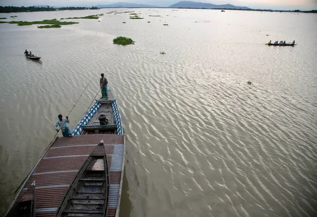 A big boat transports country boats at Balimukh village, about 70 kilometers (43 miles) east of Gauhati, India, Tuesday, September 1, 2015. Monsoon floods have inundated hundreds of villages across the northeast Indian state of Assam, killing several people and forcing some 800,000 people to leave their homes. (Photo by Anupam Nath/AP Photo)