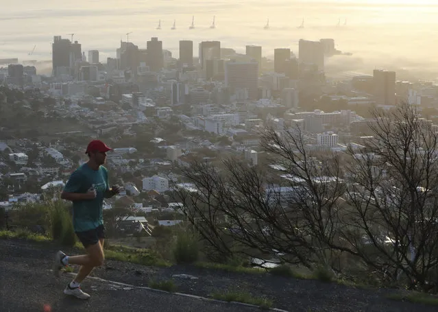 A jogger exercises in Cape Town, South Africa, Friday May 1, 2020, as the government began a phased easing of its strict lockdown measures in a bid to cut down on the spread coronavirus. For the first time in five weeks, people were permitted to walk outside for exercise between 6 a.m. and 9 a.m. (Photo by Nardus Engelbrecht/AP Photo)