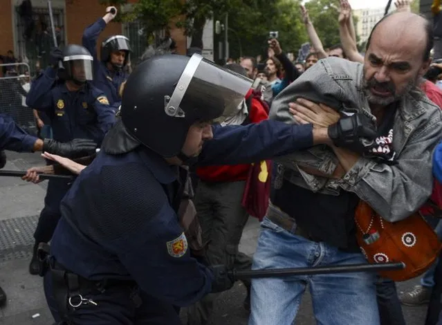 A protester clashes with a riot policeman during a demonstration organized by Spain's "indignant" protesters to decry an economic crisis they say has "kidnapped" democracy, on September 25, 2012 in Madrid. Spanish riot police fired rubber bullets and baton-charged protesters as thousands rallied near parliament in Madrid in anger at the government's handling of the economic crisis.   AFP PHOTO / PIERRE-PHILIPPE MARCOU        (Photo credit should read PIERRE-PHILIPPE MARCOU/AFP/GettyImages)