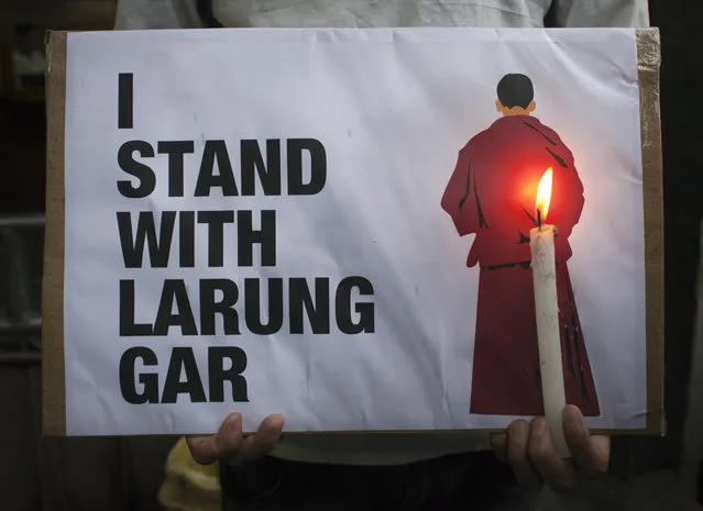 An exiled Tibetan holds a placard as he participates in a protest against the demolition of buildings in Larung Gar by Chinese authorities, during a demonstration in Dharmsala, India, Wednesday, August 10, 2016. Larun Gar is an area in eastern Tibet housing Buddhist institutions and thousands of monks and nuns. (Photo by Ashwini Bhatia/AP Photo)