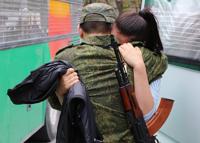 A woman says goodbye to a reservist drafted during the partial mobilisation, before his departure for a military base, in Sevastopol, Crimea on September 27, 2022. (Photo by Alexey Pavlishak/Reuters)