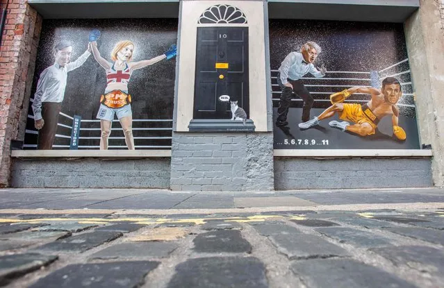 A photograph taken on September 5, 2022 shows a mural painting in Belfast city centre, made by artist Ciaran Gallagher and depicting as boxers British Foreign Secretary Liz Truss (2nd L) winning the Conservative Party leadership contest and Britain's next prime minister election over Britain's former Chancellor to the Exchequer Rishi Sunak (R) next to Britain's Prime Minister Boris Johnson (2nd R) and Britain's Brexit Opportunities and Government Efficiency Secretary Jacob Rees-Mogg (L). (Photo by Paul Faith/AFP Photo)