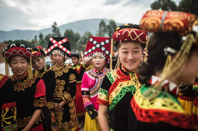 This photo taken on July 27, 2016 shows performers dressed in traditional Yi costumes at the Torch Festival in Xichang, in China's Sichuan province. For centuries, the Yi people of southwestern China have celebrated their biggest holiday of the year, the torch festival, over three days during the sixth lunar month. (Photo by Fred Dufour/AFP Photo)